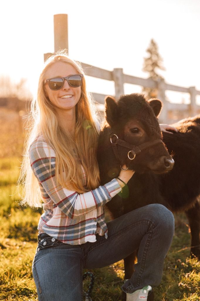 Pasture & Paw founder with calf on the farm in golden sunlight